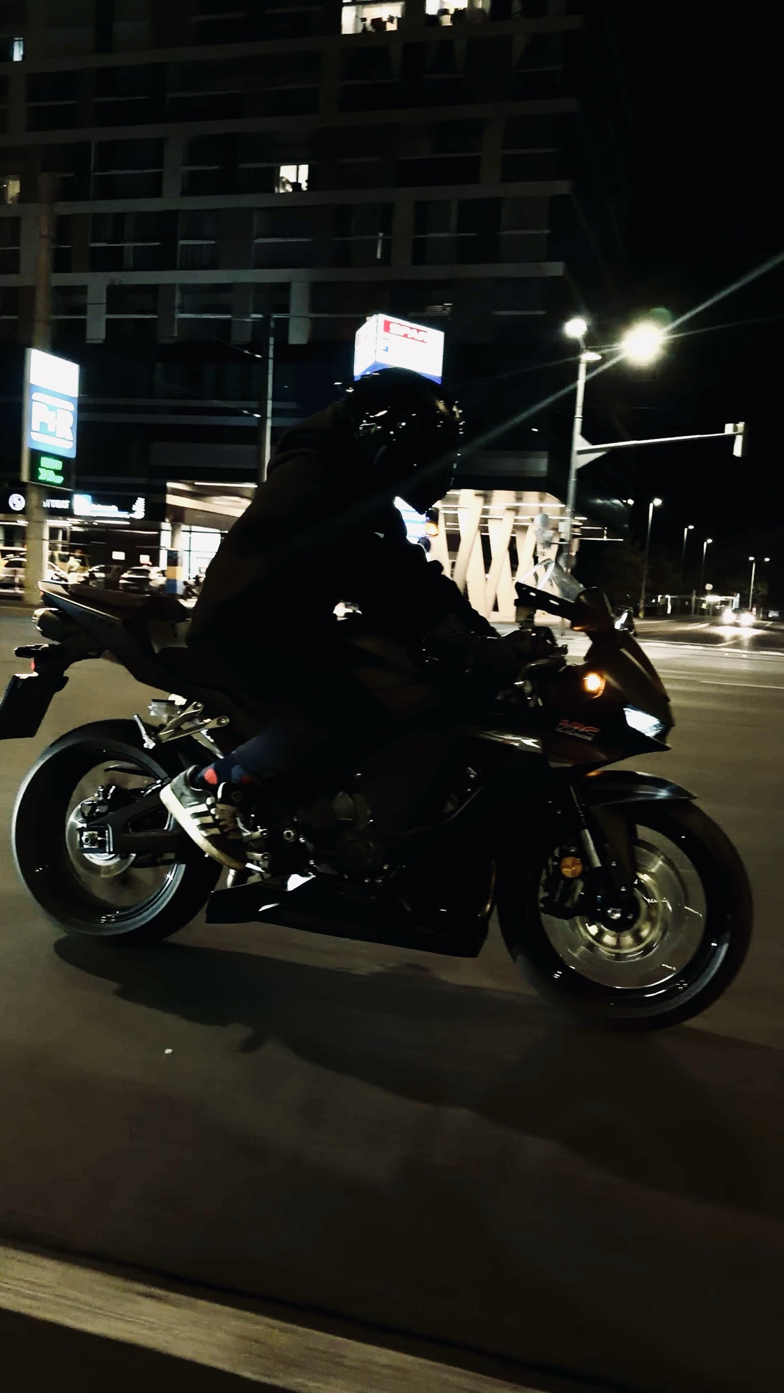 Nachtaufnahme auf einem Motorrad unter den Lichtern der Stadt